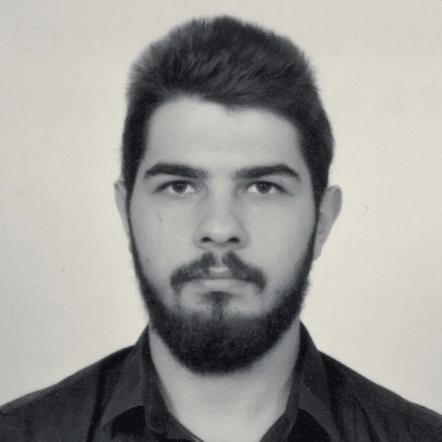 Black and white portrait of Nikolay Georgiev, a young man with short dark hair and a beard, in a dark shirt.